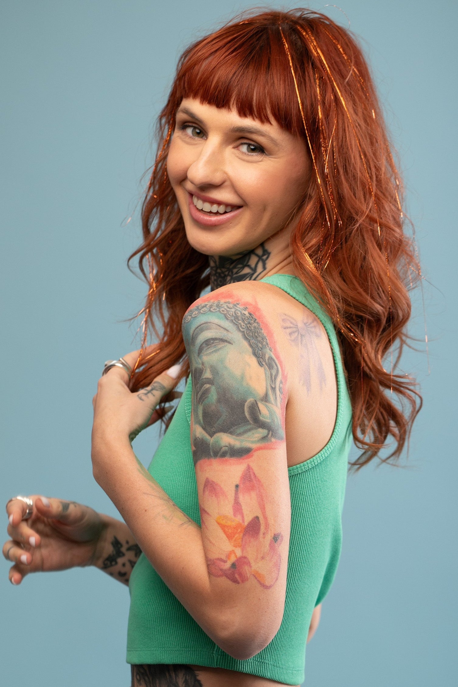 מדיום שוט על בחורה שבשיער שלה שזורים חוטי טינסל בצבעי כתום זוהר - הנקראים אצלנו גווני פיות. מיועדים לחיבור עצמאי, פשוט וקבוע לשיער או לחיבור זמני - Shufizoo