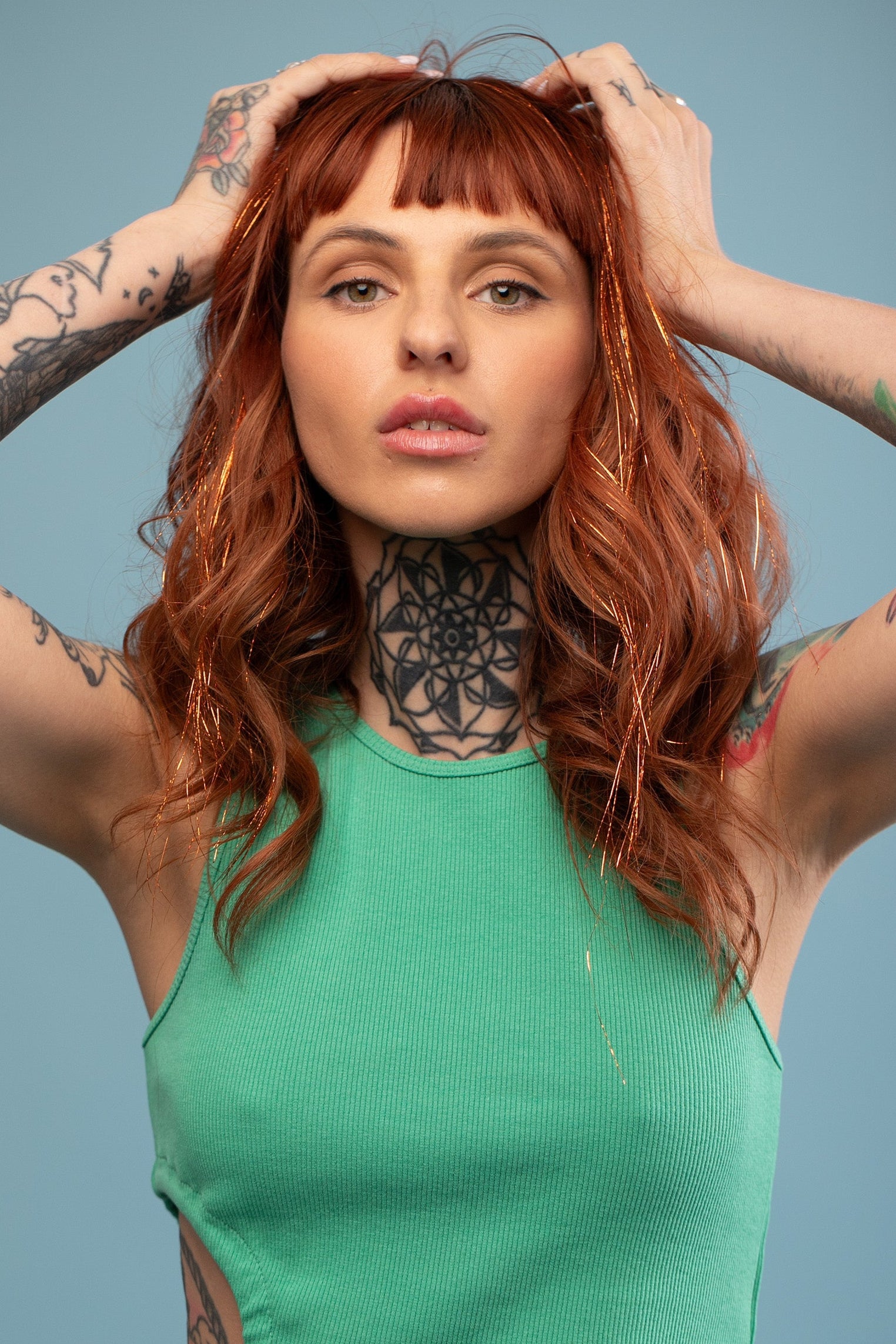 מדיום שוט על בחורה שבשיער שלה שזורים חוטי טינסל בצבעי כתום זוהר - הנקראים אצלנו גווני פיות. מיועדים לחיבור עצמאי, פשוט וקבוע לשיער או לחיבור זמני - Shufizoo