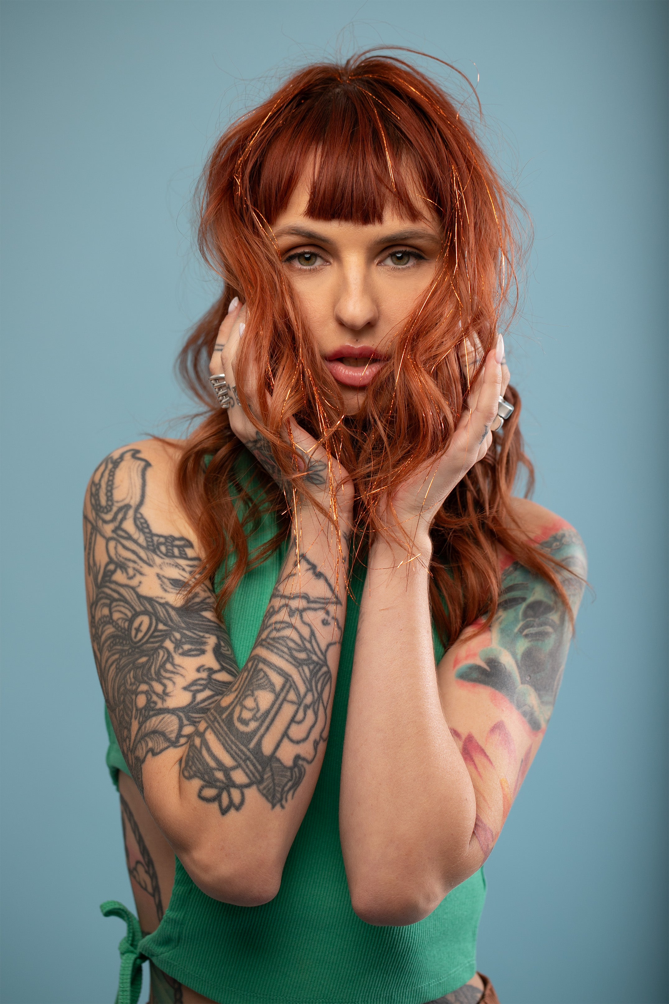 מדיום שוט על בחורה שבשיער שלה שזורים חוטי טינסל בצבעי כתום זוהר - הנקראים אצלנו גווני פיות. מיועדים לחיבור עצמאי, פשוט וקבוע לשיער או לחיבור זמני - Shufizoo